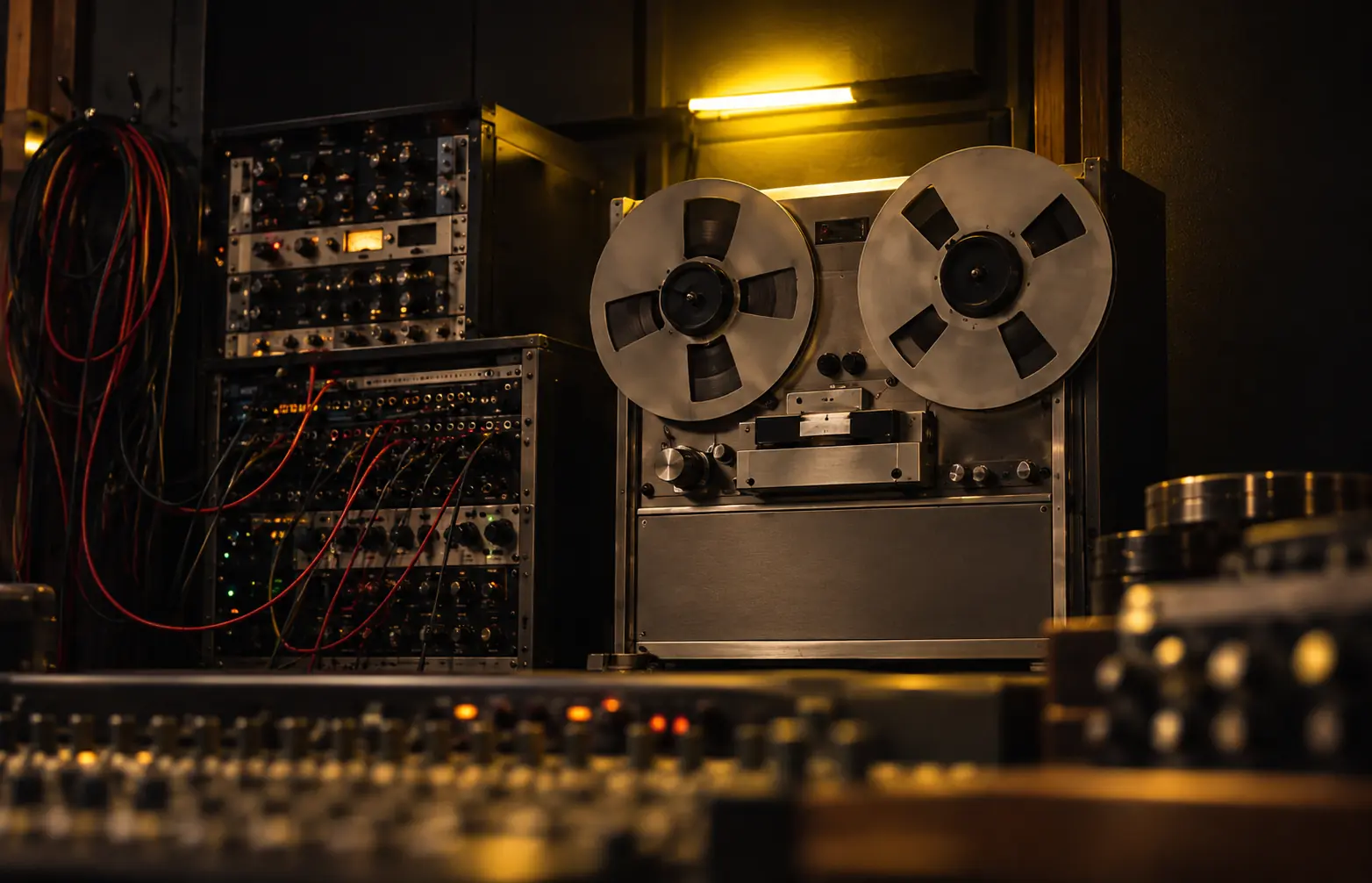 Gravador de fita de rolo e equipamentos de produção em um estúdio musical.